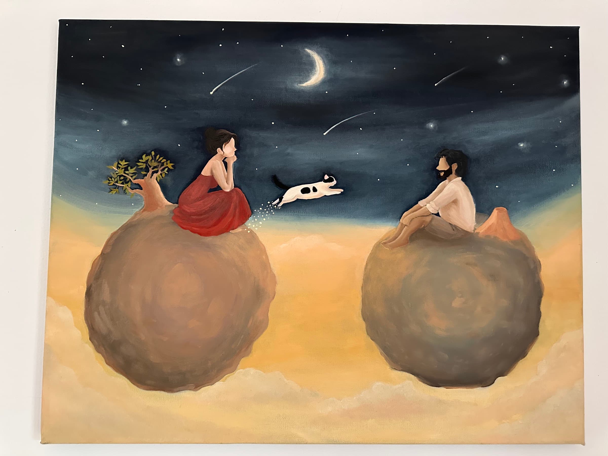 Painting of a woman in a red dress and a man sitting on two small planets under a night sky with a crescent moon, while a black-and-white cat leaps from one planet to the other